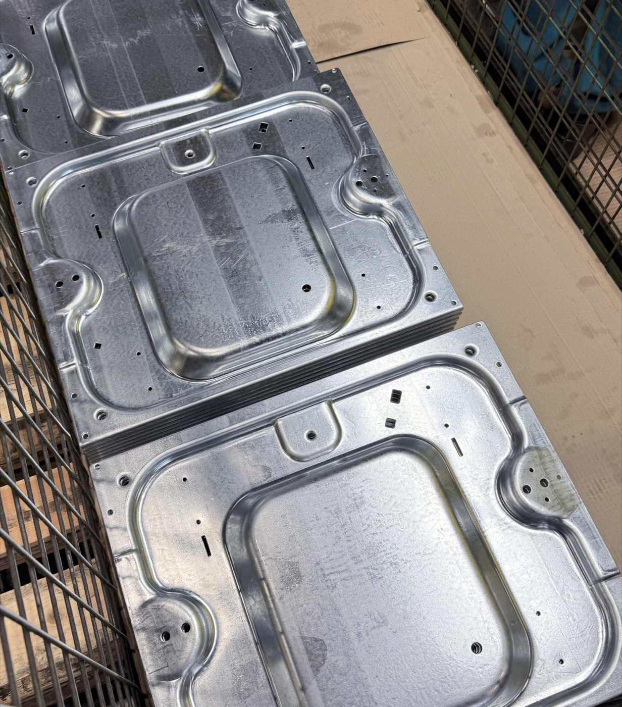 Gestanzte Metallplatten gestapelt im Gitterkorb